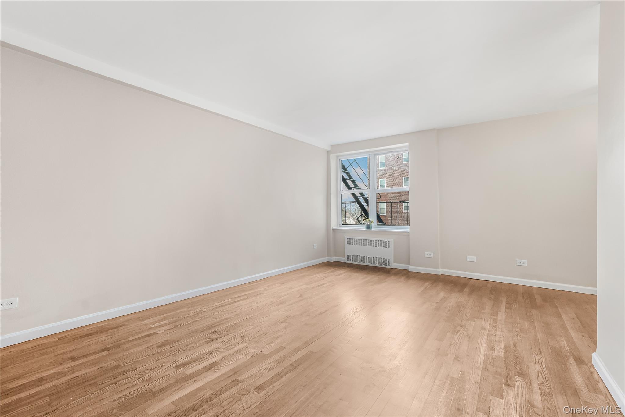 84-50 169th Street, Unit 418 Queens, NY 11432 - Photo 10 of 15 Unfurnished room with light wood-style flooring and radiator