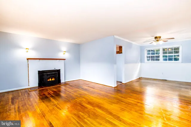 a view of an empty room with a fireplace and a window