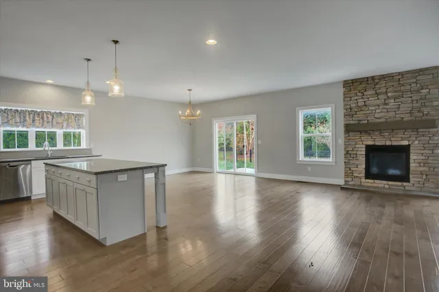 a view of a room with wooden floor fireplace and a window