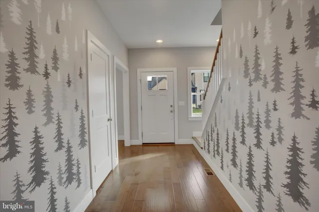 a view of a hallway with wooden floor and a shower