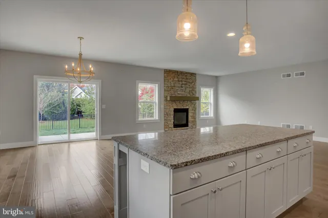 an open kitchen with fireplace and wooden floor