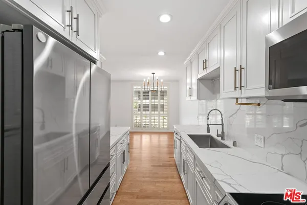a kitchen with stainless steel appliances a refrigerator and a sink