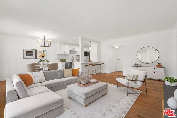 a living room with furniture kitchen view and a chandelier