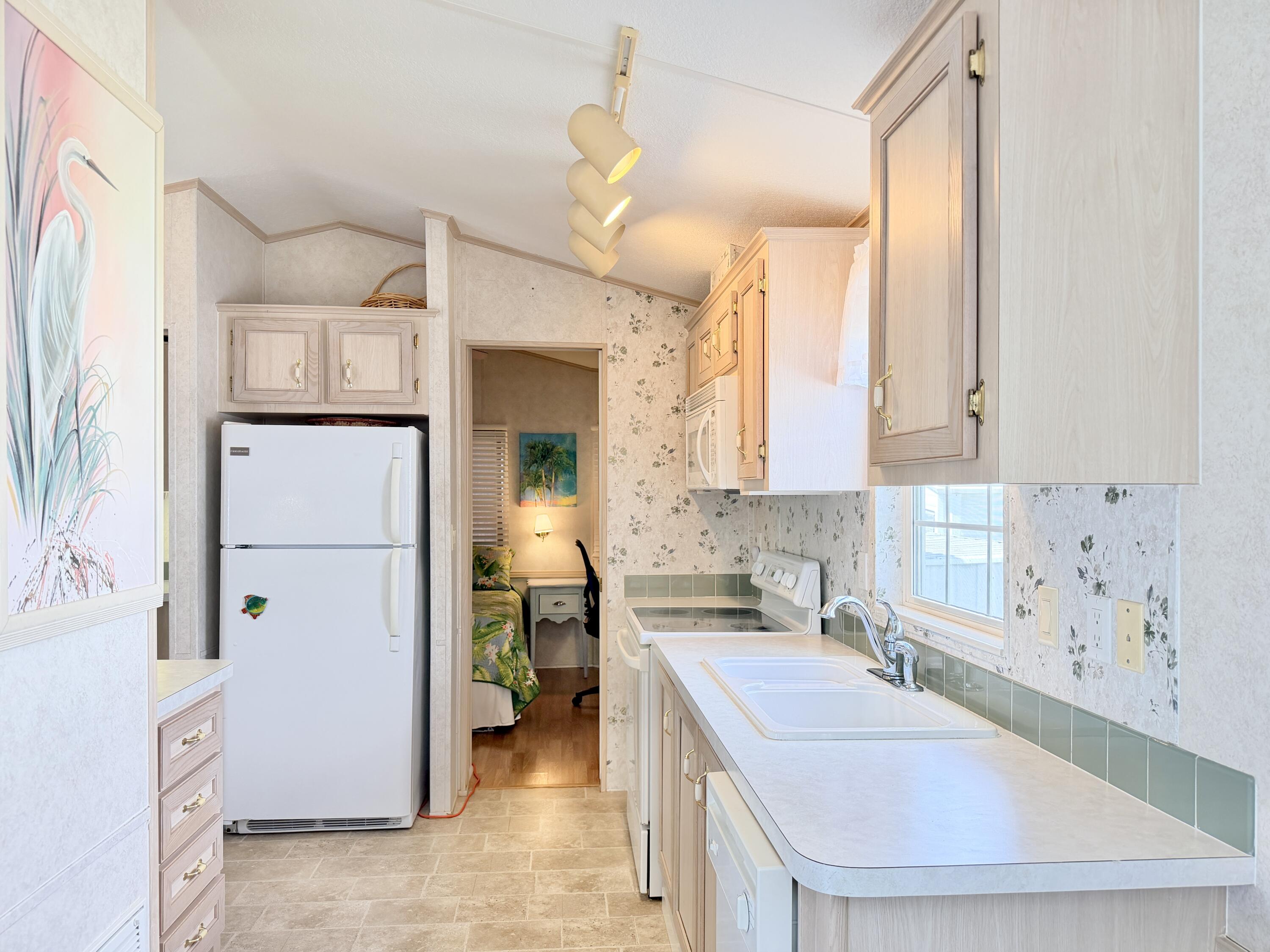 2 Jade Drive Naples, FL 34114 - Photo 8 of 44 a kitchen with a sink a stove and a refrigerator
