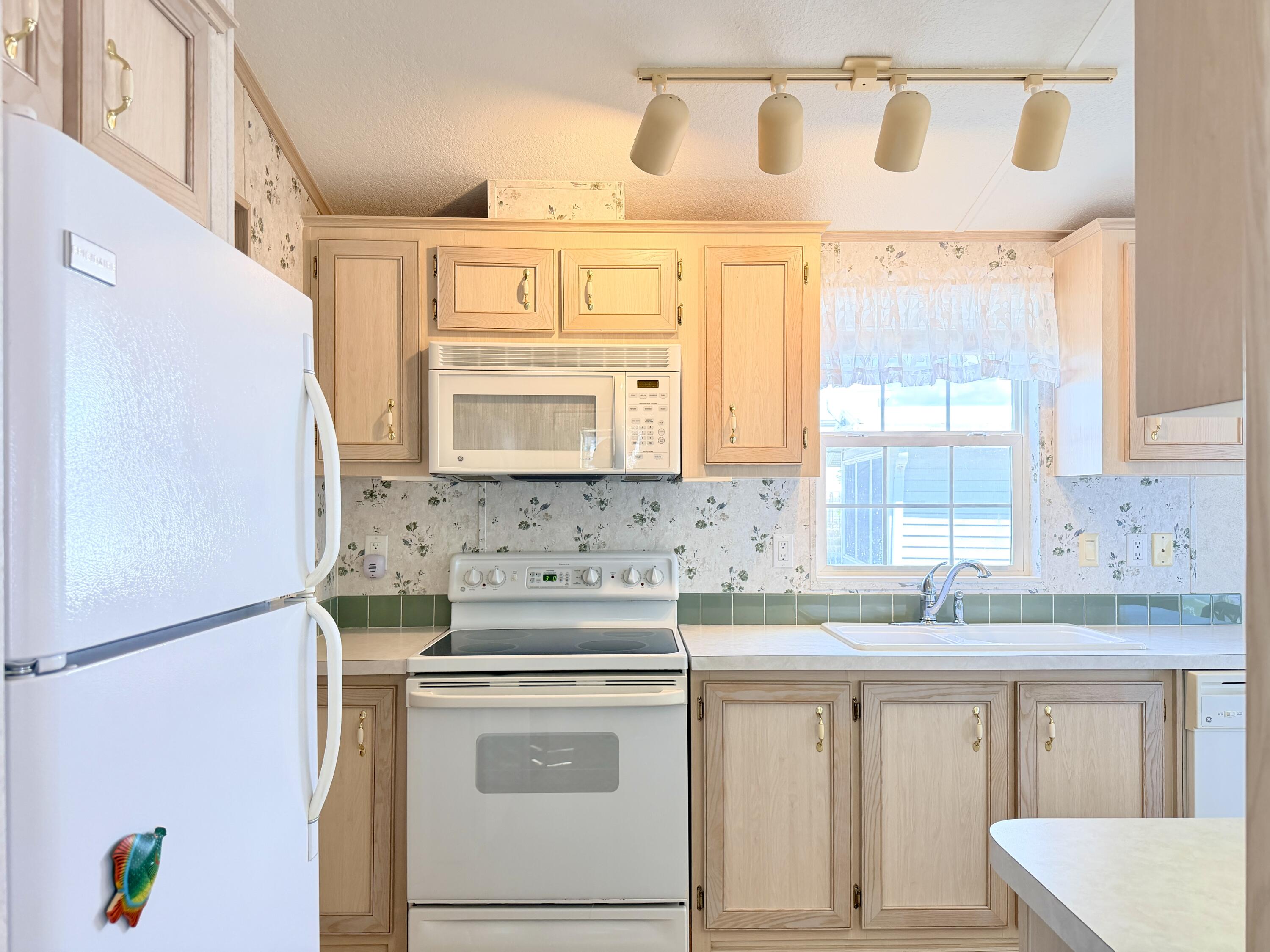 2 Jade Drive Naples, FL 34114 - Photo 9 of 44 a kitchen with a stove a sink and a refrigerator