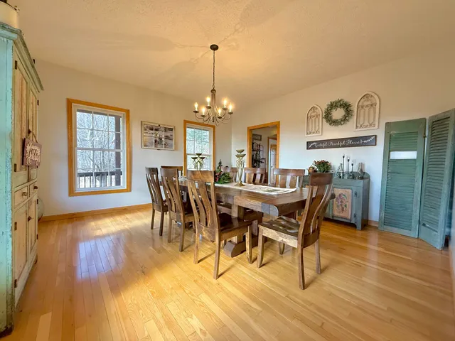 a dining room with furniture a chandelier and wooden floor