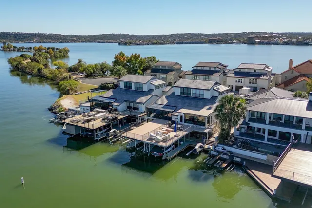 a aerial view of a house with swimming pool a yard and a patio