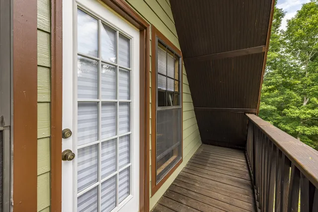 a view of a hallway with wooden floor windows and a living room