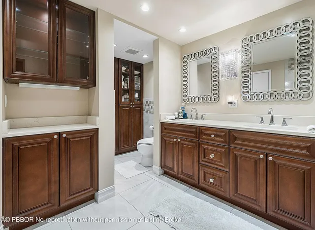 a bathroom with a granite countertop sink mirror vanity and toilet