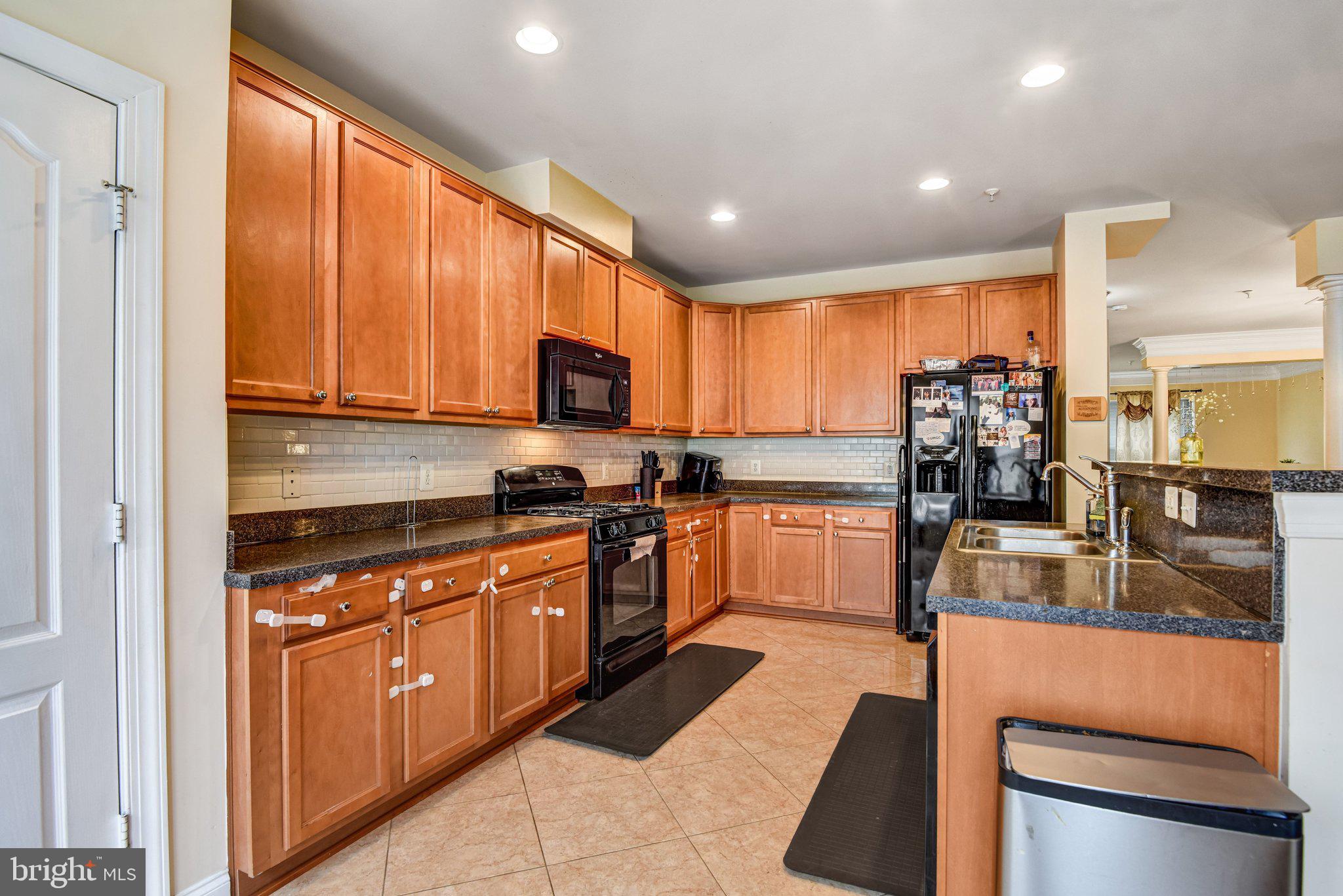 4112 Potomac Highlands Circle Triangle, VA 22172 - Photo 5 of 41 a kitchen with stainless steel appliances granite countertop wooden cabinets a stove top oven a sink and dishwasher