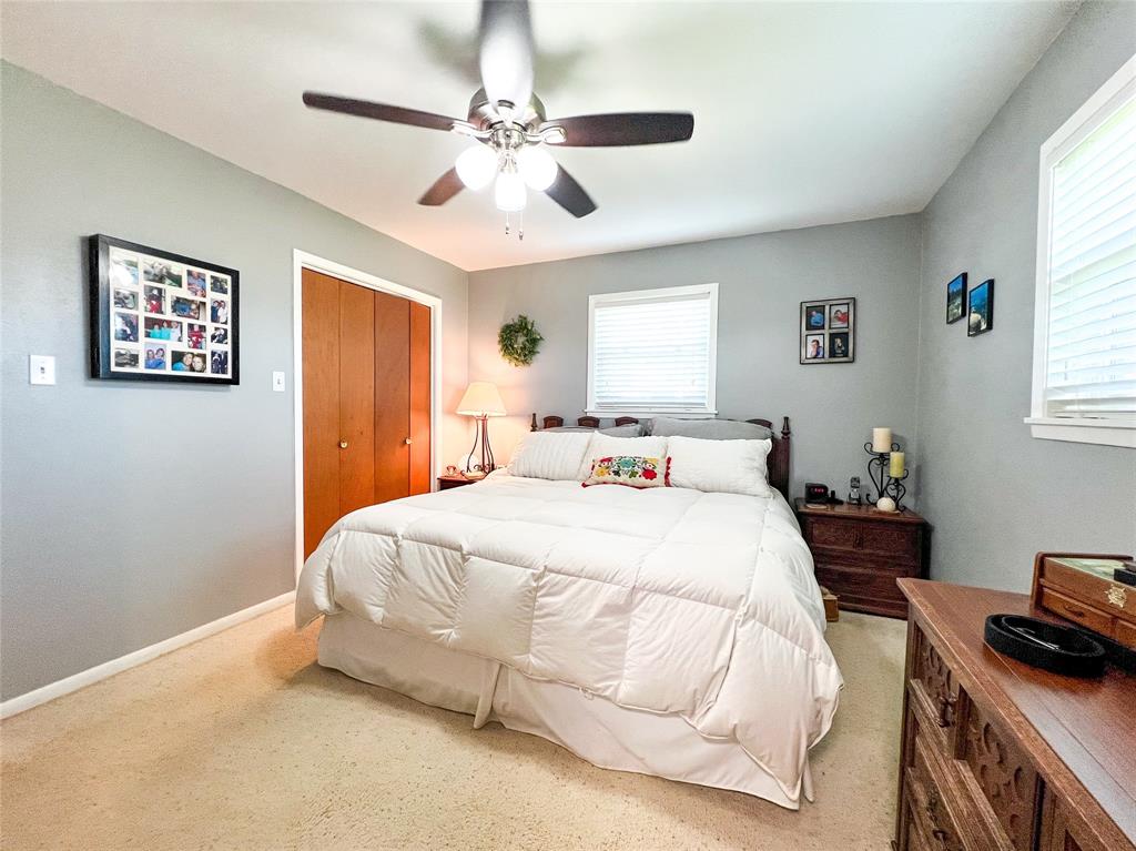1009 North 7th Street Haskell, TX 79521 - Photo 17 of 26 a spacious bedroom with a bed and a chandelier