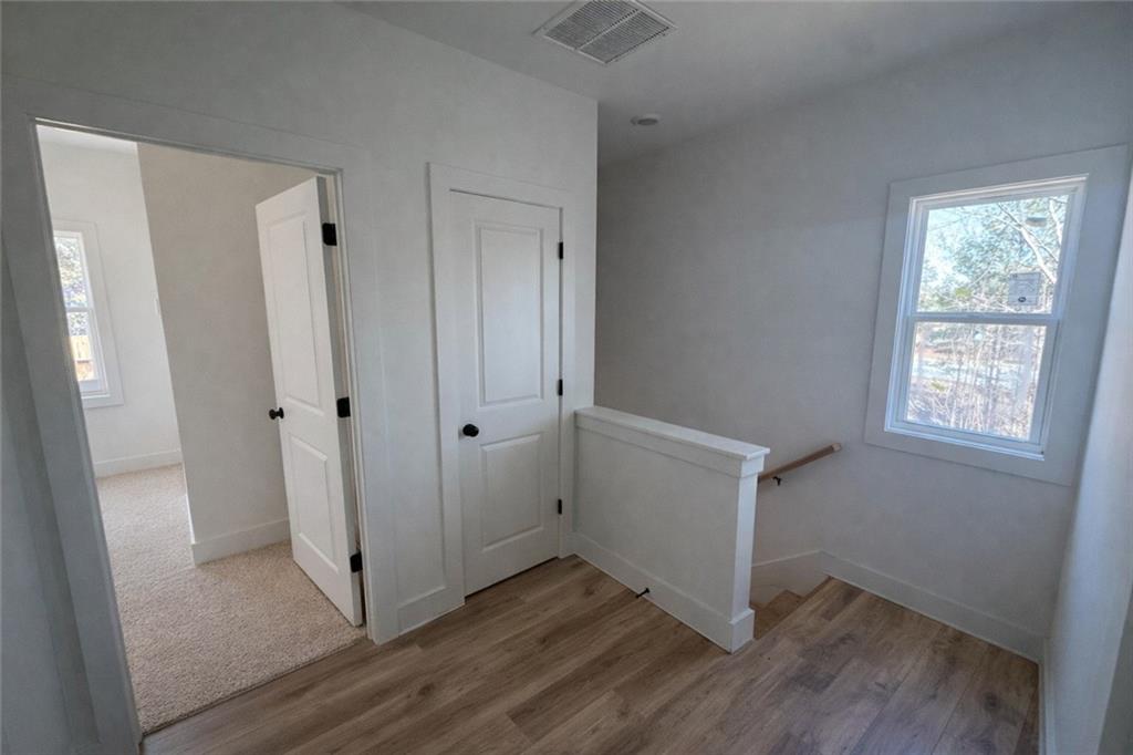 287 Bell Grove Lane Suwanee, GA 30024 - Photo 11 of 29 a view of an empty room with wooden floor and a window
