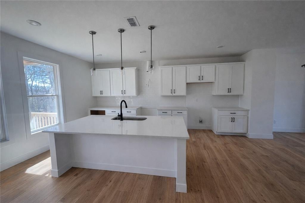 287 Bell Grove Lane Suwanee, GA 30024 - Photo 5 of 29 a kitchen with kitchen island white cabinets and appliances