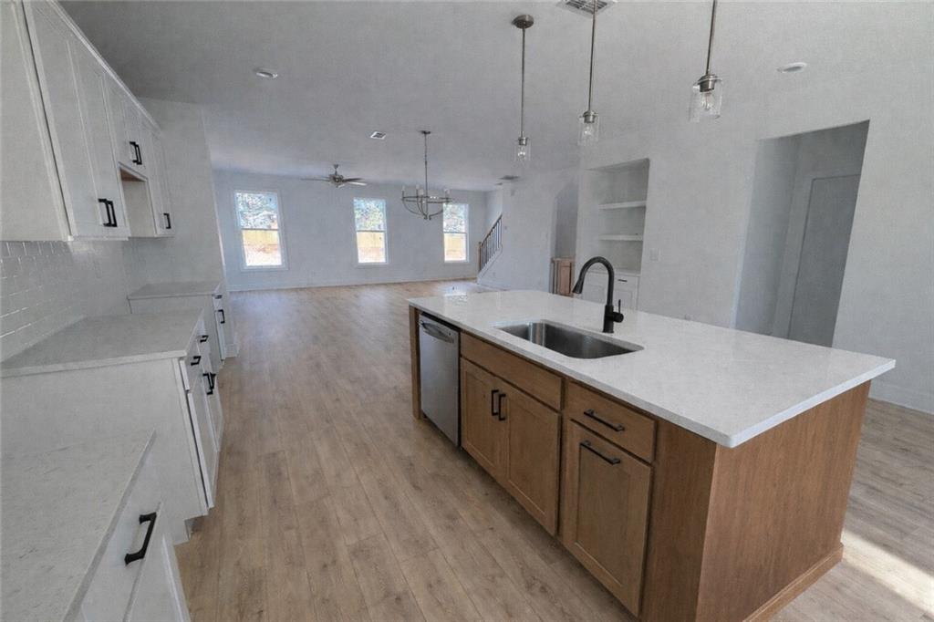 287 Bell Grove Lane Suwanee, GA 30024 - Photo 6 of 29 a kitchen with stainless steel appliances a sink a window a wooden floor and a window