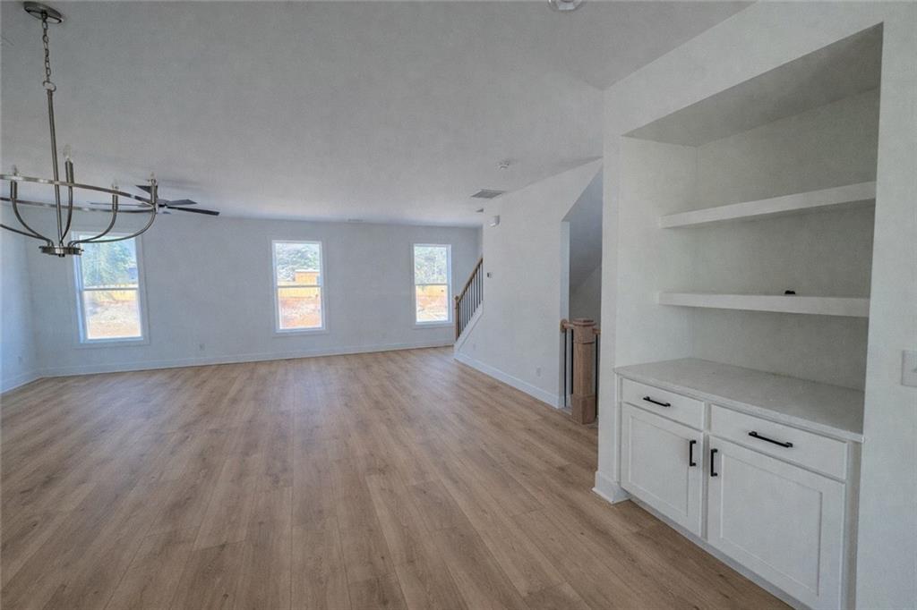 287 Bell Grove Lane Suwanee, GA 30024 - Photo 7 of 29 a view of an empty room with window and wooden floor