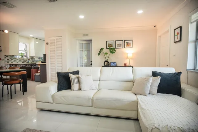 a living room with furniture and a dining table with wooden floor