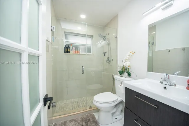 a bathroom with a sink a toilet and shower