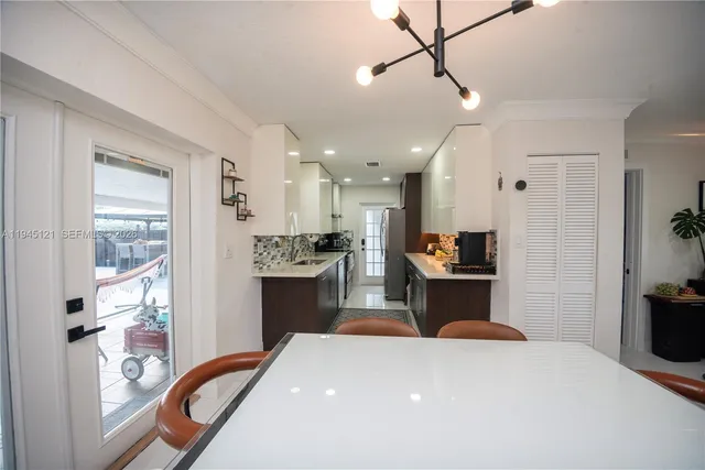 a kitchen with kitchen island a counter top space a sink stainless steel appliances and cabinets