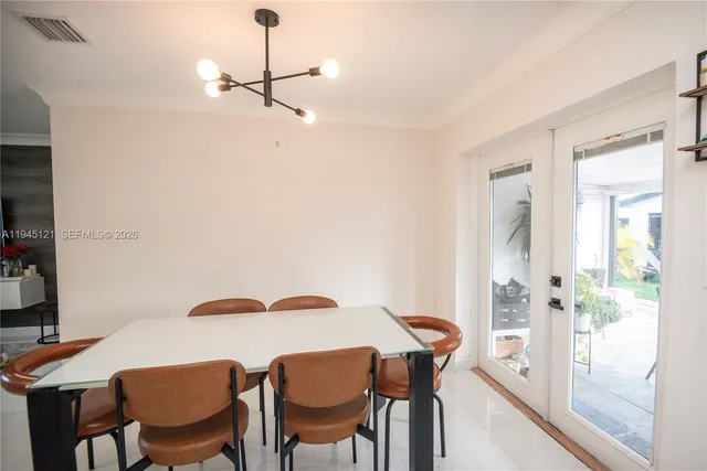 a view of a dining room with furniture and a chandelier