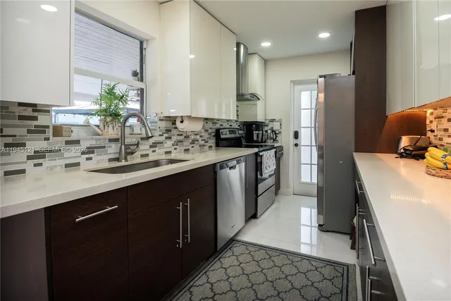 a kitchen with stainless steel appliances a sink stove and refrigerator