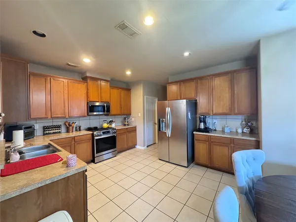 a kitchen with refrigerator and cabinets