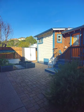 a view of a house with backyard and a tree