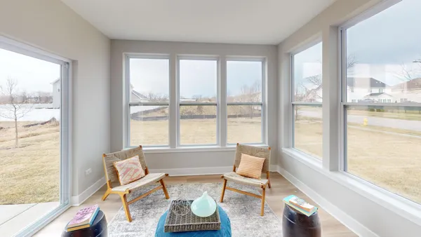 a living room with furniture and floor to ceiling windows