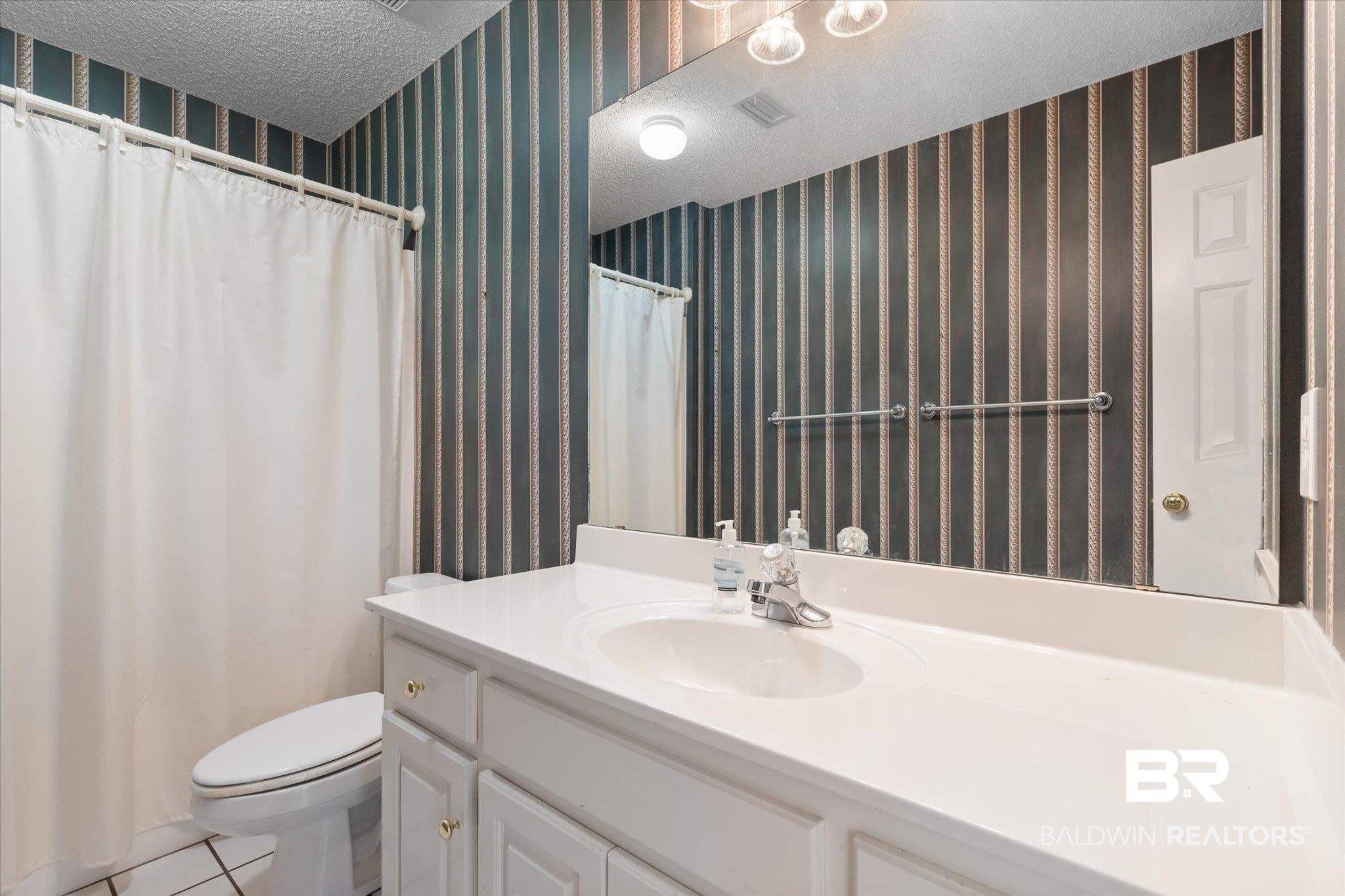 2220 Irongate Court Mobile, AL 36695 - Photo 15 of 20 Full bathroom with vanity, a textured ceiling, toilet, and wallpapered walls