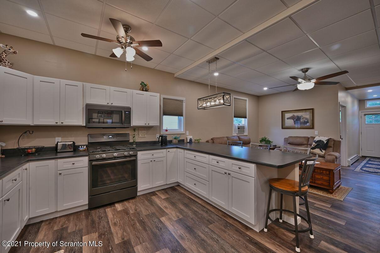 303 Main Street Nicholson, PA 18446 - Photo 10 of 98 a kitchen with stainless steel appliances granite countertop a sink dishwasher a stove refrigerator and cabinets with wooden floor