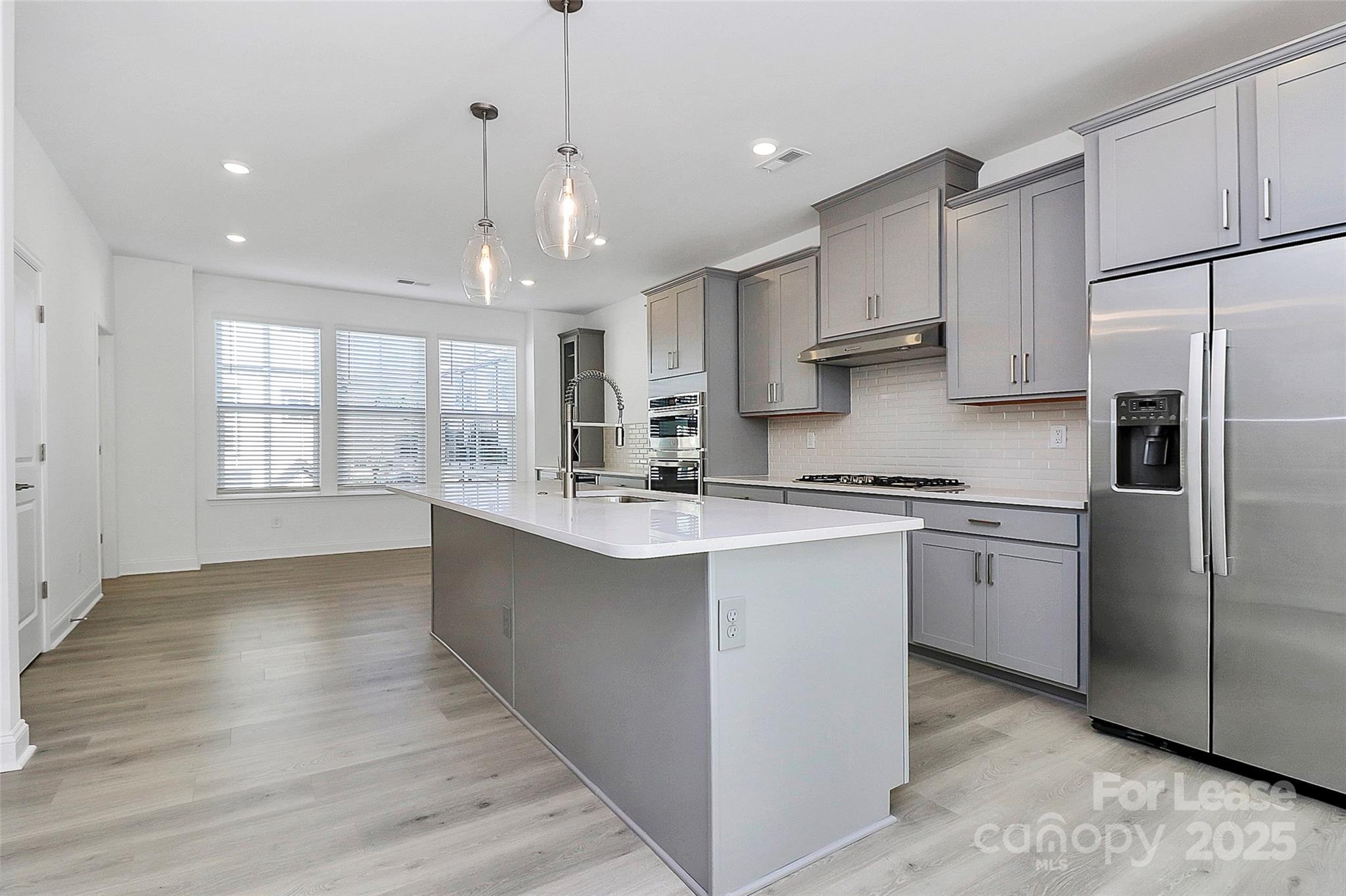 707 Hoke Lane Davidson, NC 28036 - Photo 11 of 27 a kitchen with stainless steel appliances granite countertop a refrigerator a sink dishwasher a stove and white countertops with wooden floor