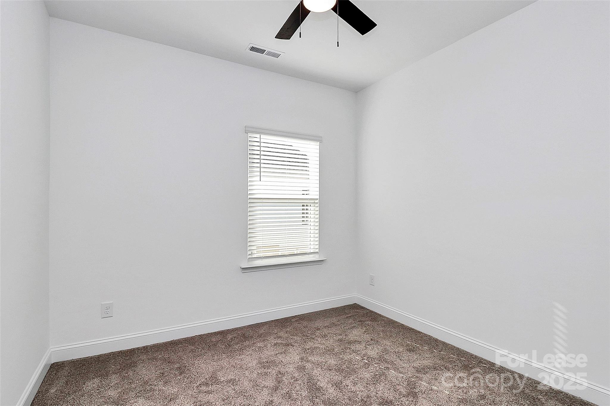 707 Hoke Lane Davidson, NC 28036 - Photo 19 of 27 an empty room with a window and a ceiling fan