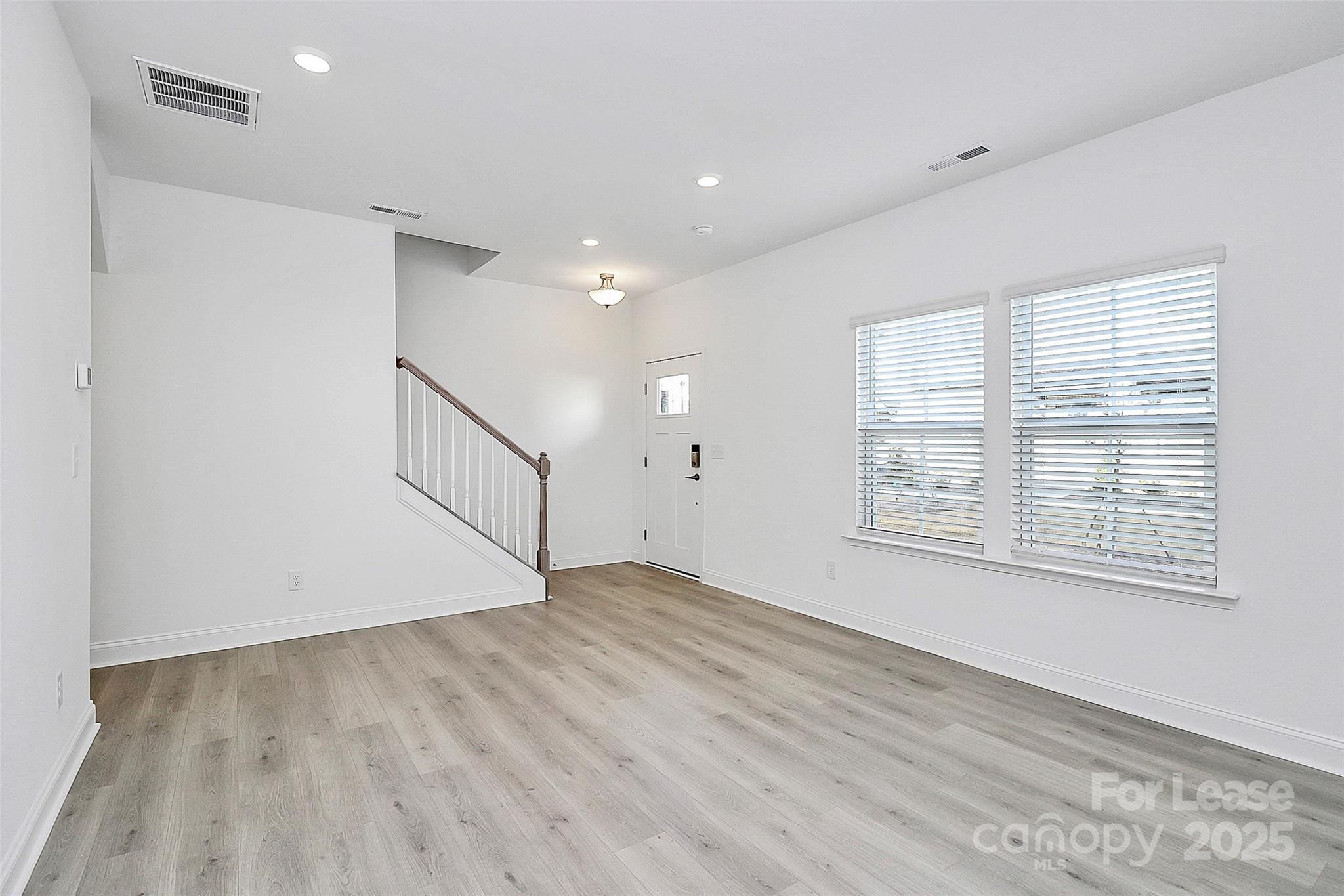 707 Hoke Lane Davidson, NC 28036 - Photo 2 of 27 a view of an empty room with wooden floor and a window