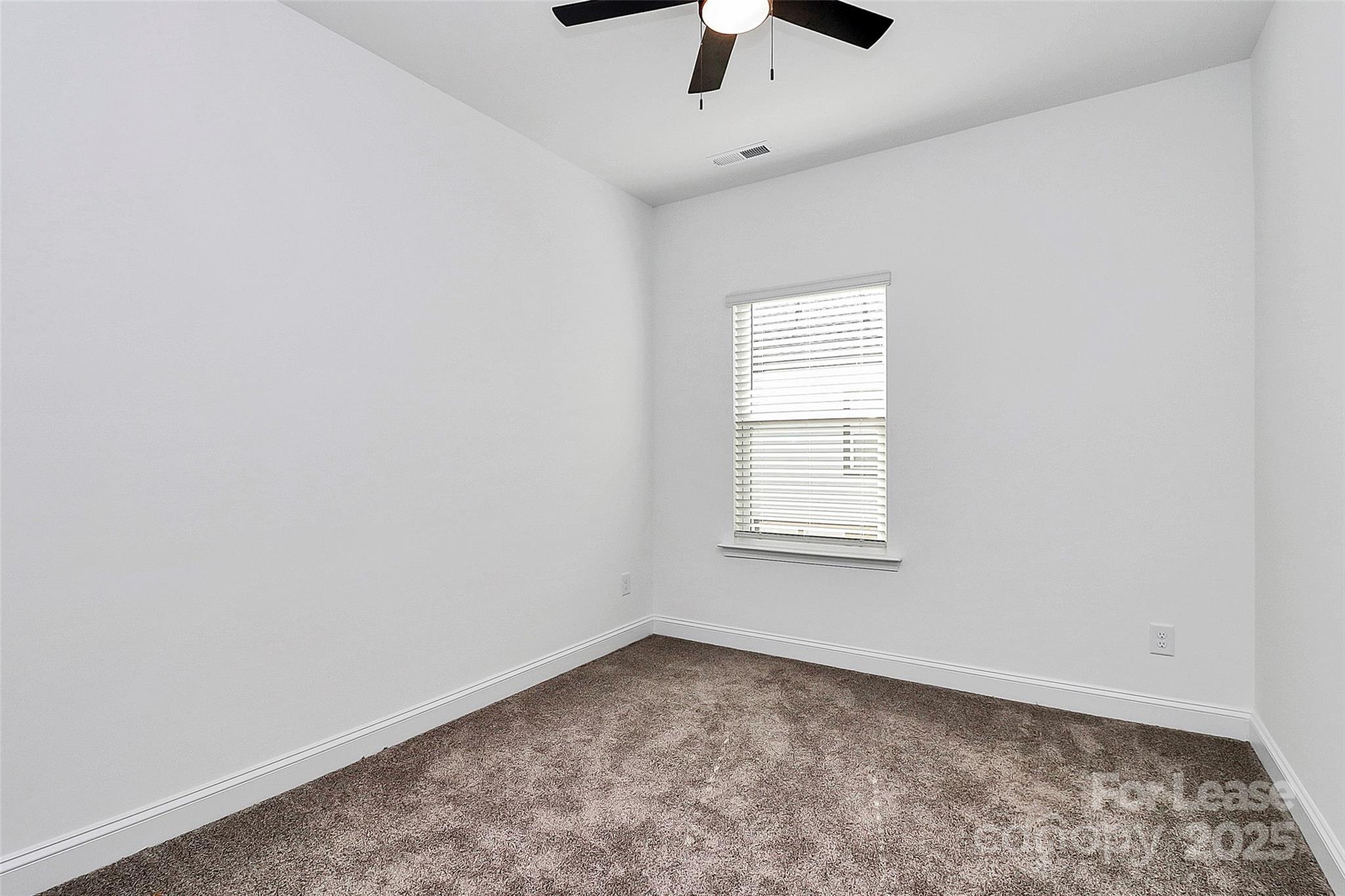 707 Hoke Lane Davidson, NC 28036 - Photo 22 of 27 an empty room with a window and a fan