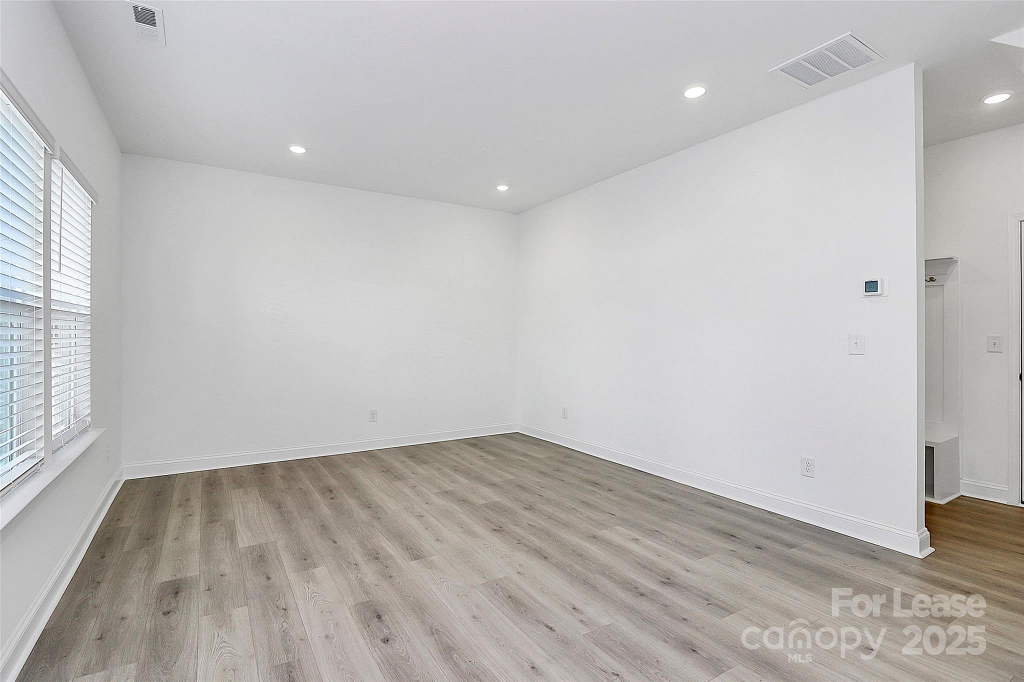 707 Hoke Lane Davidson, NC 28036 - Photo 3 of 27 an empty room with wooden floor and windows