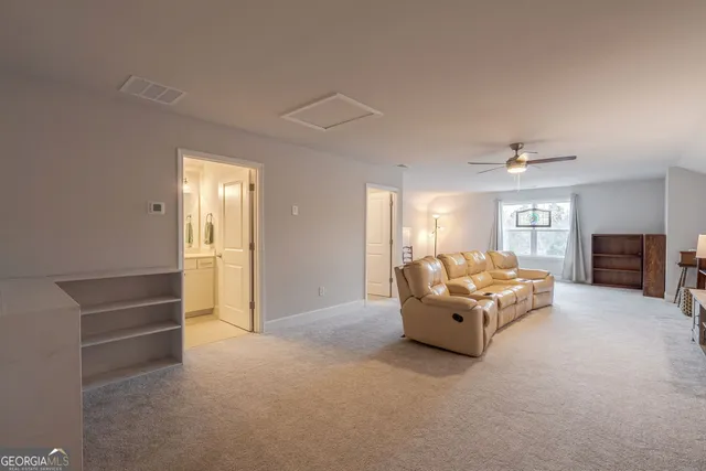 a living room with furniture and a book shelf