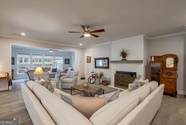 a living room with furniture a flat screen tv and a window