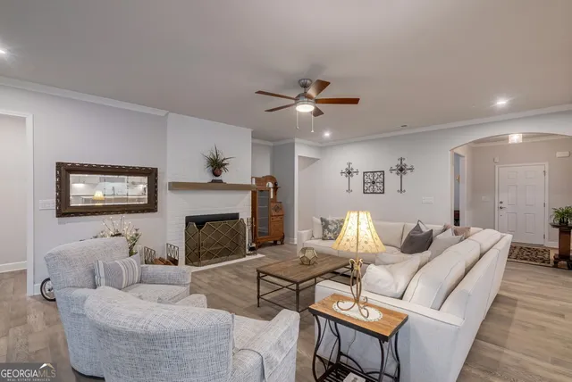a living room with furniture a fireplace and a large window