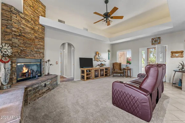 a living room with furniture a fireplace and a chandelier