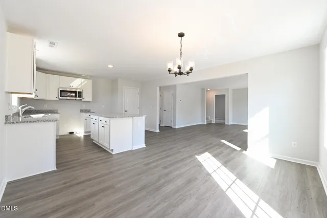 a large kitchen with cabinets wooden floor and stainless steel appliances