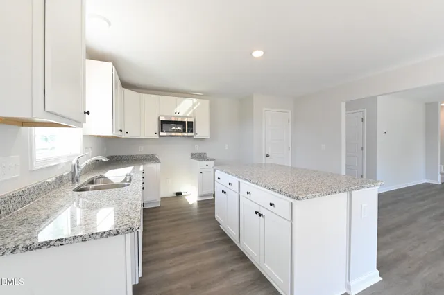 a kitchen with granite countertop a sink and a stove top oven