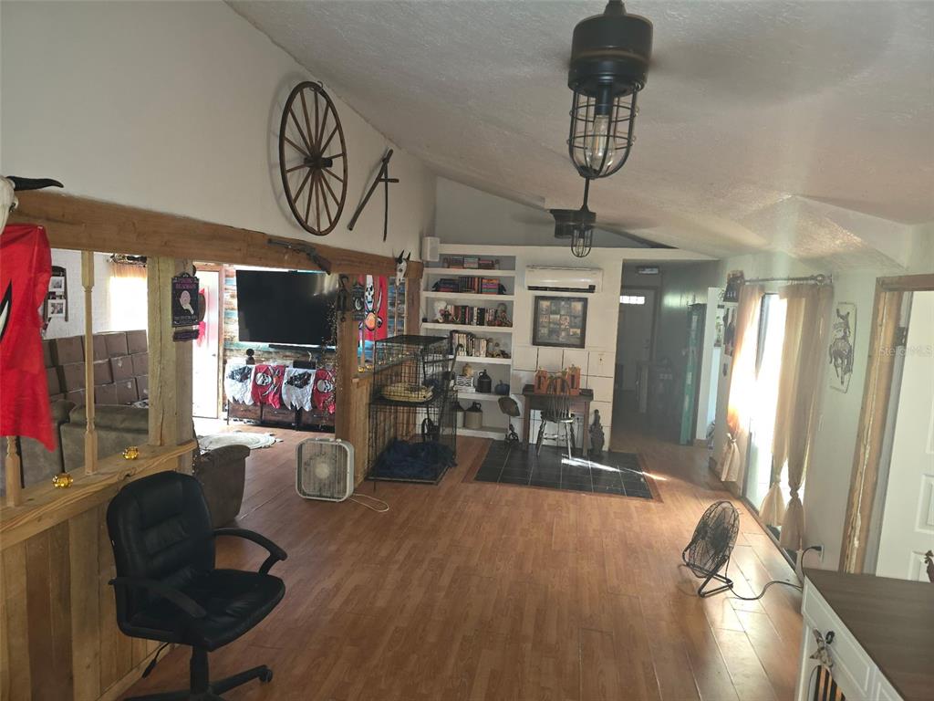 12510 Robinhood Road Hudson, FL 34669 - Photo 3 of 30 a living room with furniture a chandelier and a flat screen tv