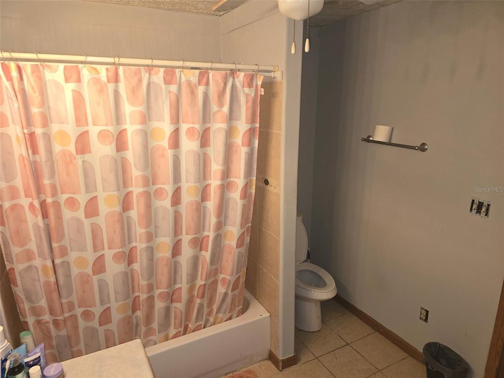 12510 Robinhood Road Hudson, FL 34669 - Photo 5 of 30 a bathroom with a toilet and a shower curtain