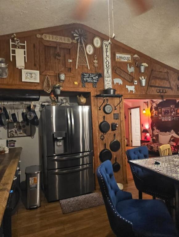 12510 Robinhood Road Hudson, FL 34669 - Photo 7 of 30 a kitchen with granite countertop a refrigerator a stove a dining table and chairs with wooden floor