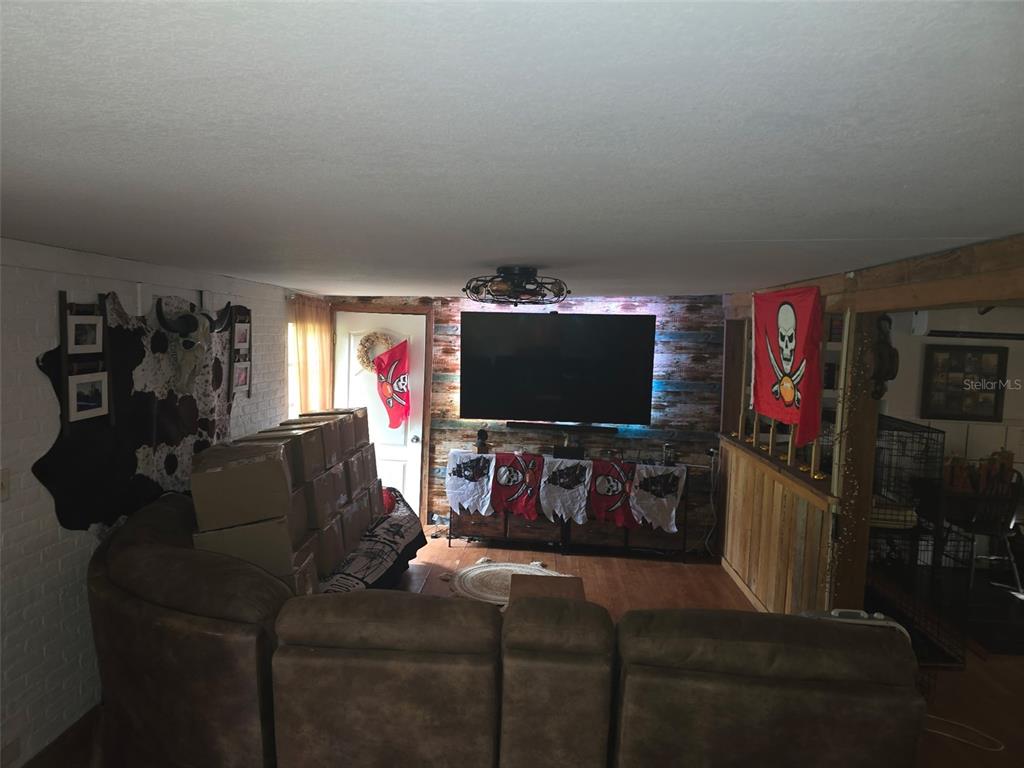 12510 Robinhood Road Hudson, FL 34669 - Photo 9 of 30 a living room with furniture and a flat screen tv