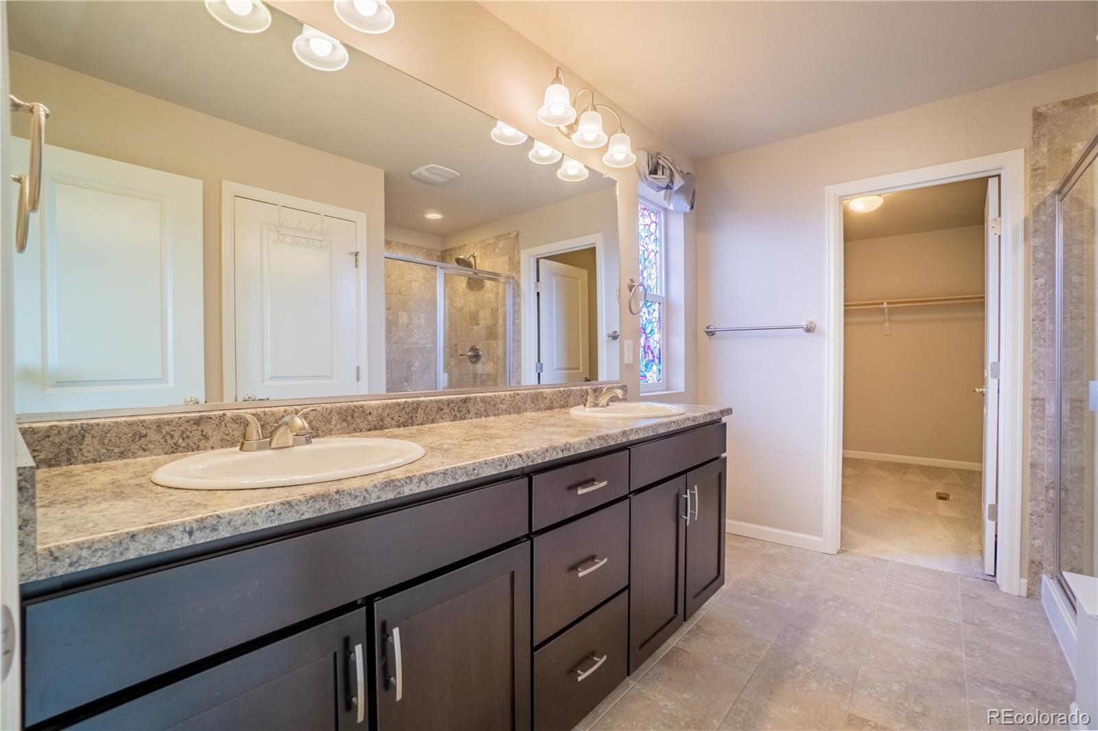 643 Ranchhand Drive Berthoud, CO 80513 - Photo 20 of 39 a bathroom with a granite countertop double vanity sink and a mirror