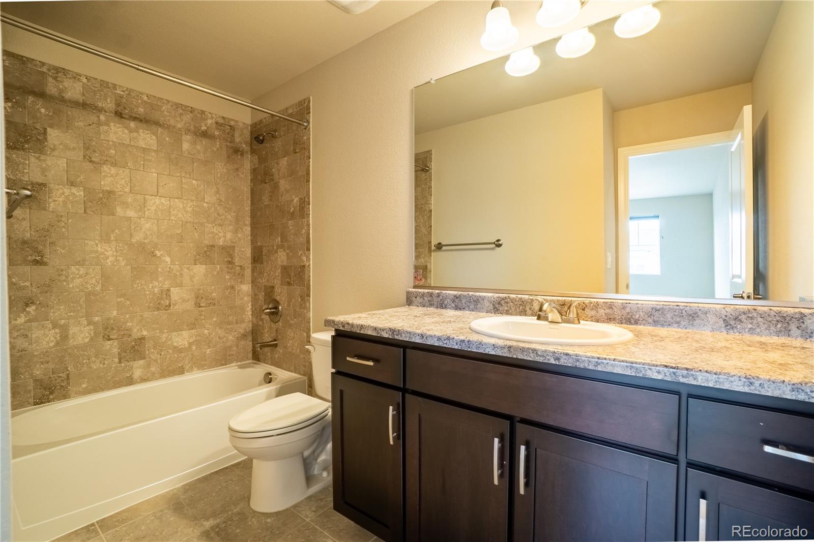 643 Ranchhand Drive Berthoud, CO 80513 - Photo 27 of 39 a bathroom with a granite countertop sink toilet mirror and shower