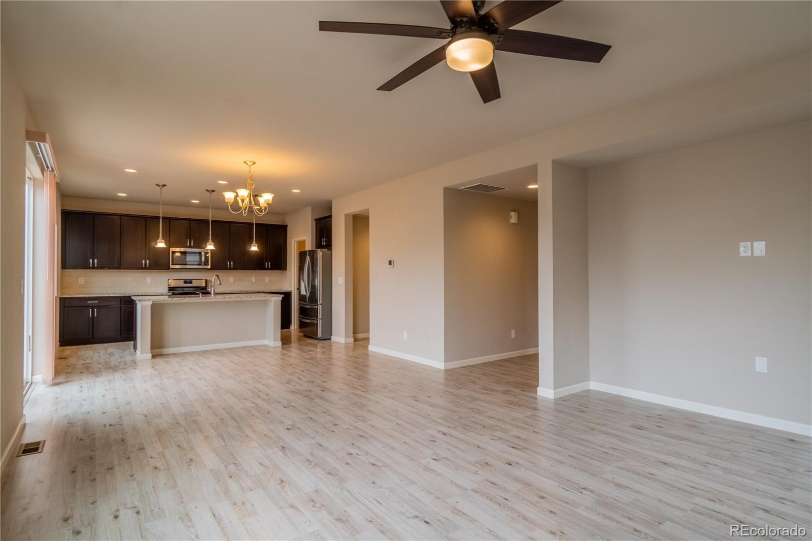 643 Ranchhand Drive Berthoud, CO 80513 - Photo 4 of 39 a view of kitchen with kitchen island wooden floor and stainless steel appliances