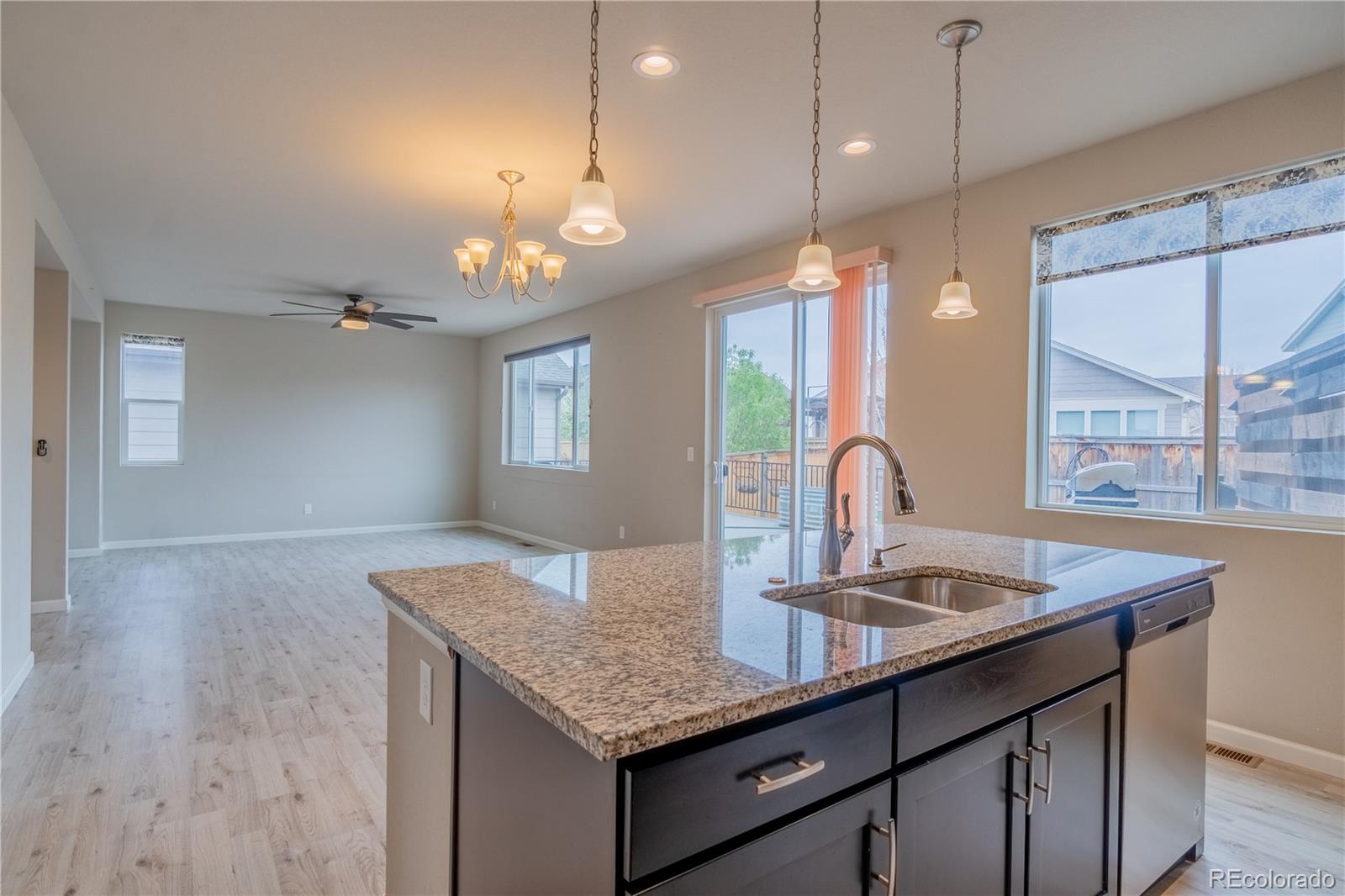643 Ranchhand Drive Berthoud, CO 80513 - Photo 8 of 39 a kitchen with kitchen island granite countertop a sink cabinets and window