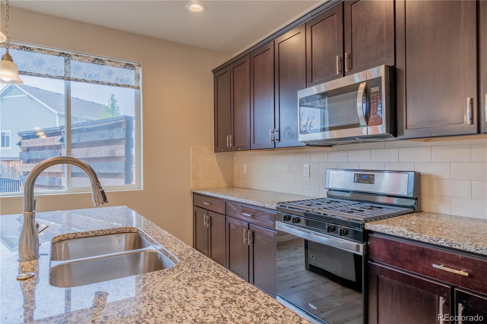 643 Ranchhand Drive Berthoud, CO 80513 - Photo 9 of 39 a kitchen with stainless steel appliances granite countertop a stove and a microwave