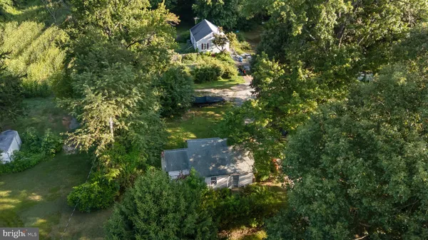 an aerial view of residential house with outdoor space and trees all around